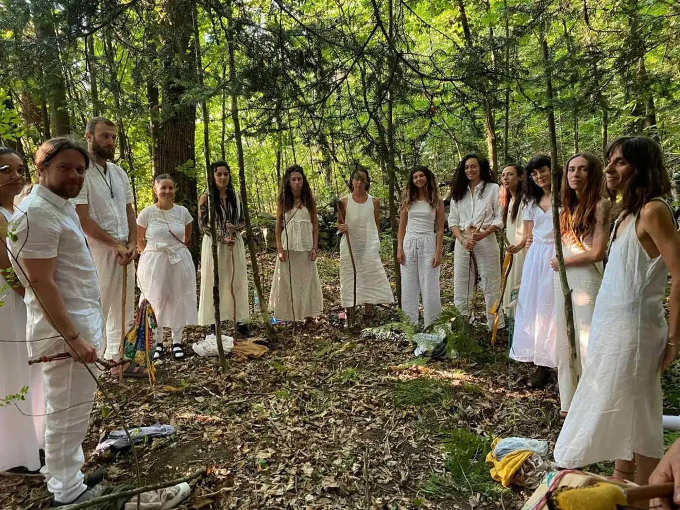 Un cerchio di donne vestite di bianco nel bosco